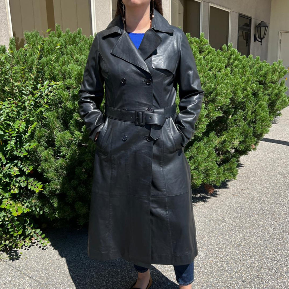 Trench-coat classique en cuir pour femme. Double boutonnage avec ceinture ajustable.